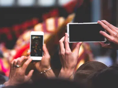 A group of people taking pictures with their cell phones.