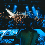 A dj on stage in front of a crowd of people.