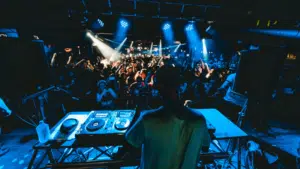 A dj on stage in front of a crowd of people.