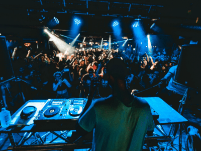 A dj on stage in front of a crowd of people.