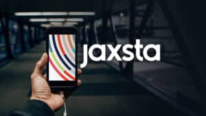 A person holding up a phone with the jaxsta logo on it.