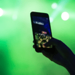 A person taking a photo with a cell phone at a concert.