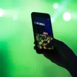 A person taking a photo with a cell phone at a concert.