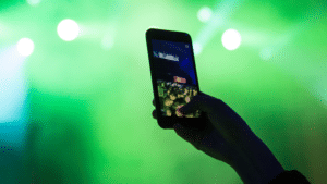 A person taking a photo with a cell phone at a concert.