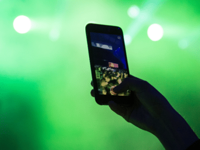 A person taking a photo with a cell phone at a concert.