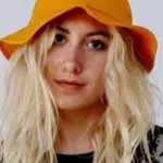 A blonde woman wearing an orange bucket hat.