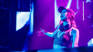 A female dj on stage at a concert.