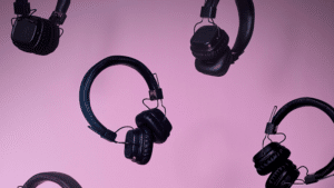 A group of headphones on a pink background.