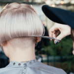 A woman is getting her hair cut in a salon.
