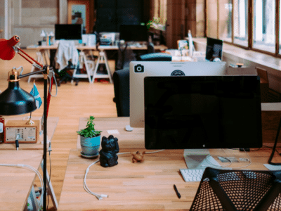 An empty office with two monitors and a lamp.