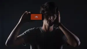 A man holding up a phone with an orange screen on it.