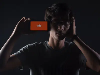 A man holding up a phone with an orange screen on it.