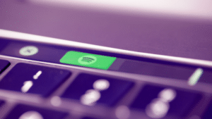 A close up of a laptop keyboard with a spotify button.