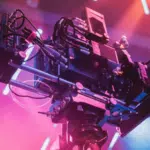 A video camera on a stage with colorful lights.