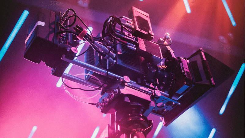 A video camera on a stage with colorful lights.