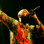A man in a colorful shirt singing into a microphone.