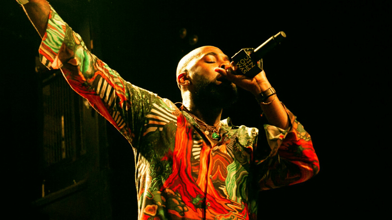 A man in a colorful shirt singing into a microphone.