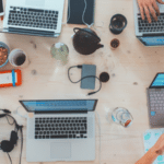 A social gathering with people working on laptops at a table.