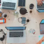 A social gathering with people working on laptops at a table.