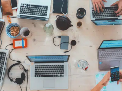 A social gathering with people working on laptops at a table.