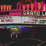 The grand lake theater is illuminated at night.