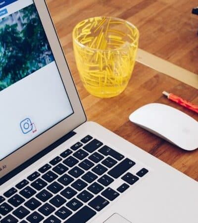 A laptop advertising online sitting on a wooden table.