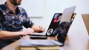 A publicist working at a desk with two laptops.