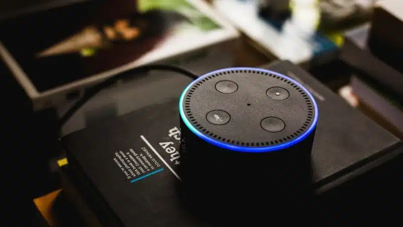 An Echo Dot sits on top of a book, showcasing Amazon Music capabilities.