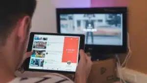 A man is using an iPad to watch a TV show on YouTube.