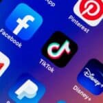 A phone screen displays TikTok and social media icons.