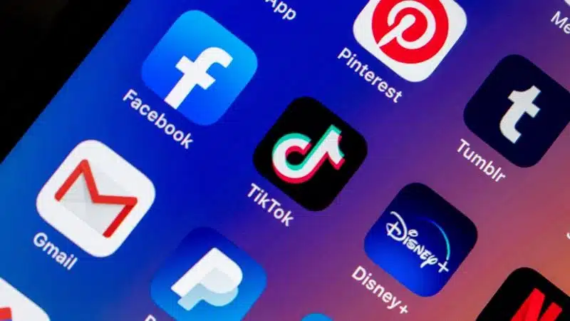 A phone screen displays TikTok and social media icons.