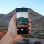 A person showcasing IG Reels with a picture of a mountain in the background.