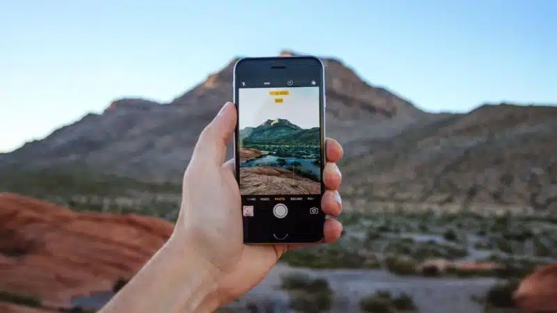 A person showcasing IG Reels with a picture of a mountain in the background.