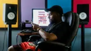 A man in front of colorful speakers.