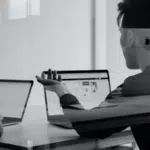 A black and white legal photo of two people working on laptops.