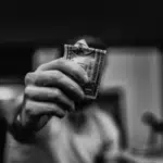 A black and white photo of a man holding dollar bills.