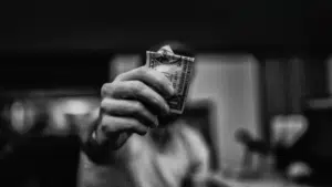 A black and white photo of a man holding dollar bills.