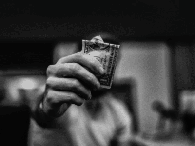A black and white photo of a man holding dollar bills.