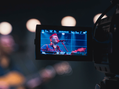 A video camera capturing a man singing, aiming to sell more merch.