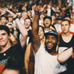 A crowd of people cheering at a concert during a music industry podcast event.