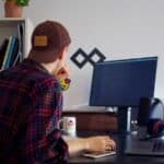 A music supervisor working at a desk with a computer.