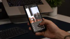 A hand holding a smartphone capturing social media content.
