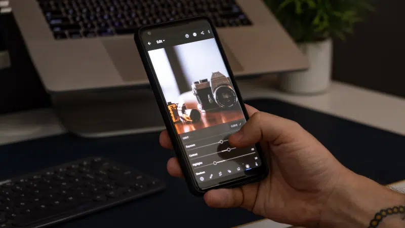 A hand holding a smartphone capturing social media content.