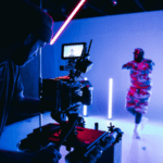 A man is filming a synchronized video in a dark room.