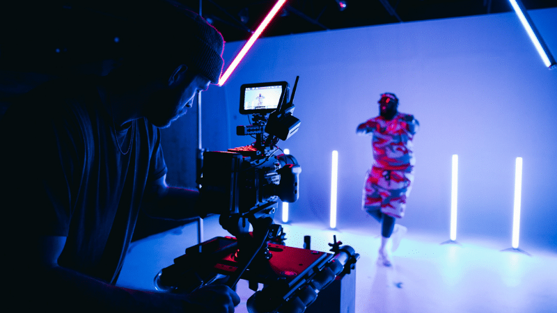 A man is filming a synchronized video in a dark room.