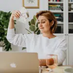 A woman sitting at a desk with money in her hands, representing an image often associated with producers.