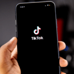 A person showcasing the tikk logo on a smartphone to increase views on TikTok.