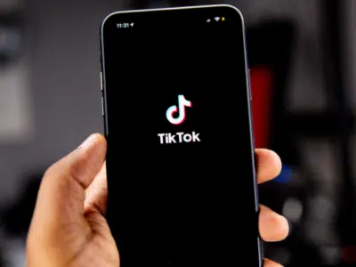 A person showcasing the tikk logo on a smartphone to increase views on TikTok.