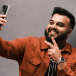 A man is taking a selfie for TikTok with his phone.