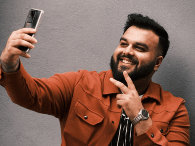 A man is taking a selfie for TikTok with his phone.